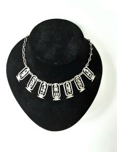 Egyptian Revival silver necklace on stand